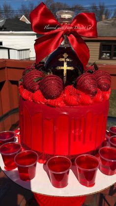 a cake with red icing and decorations on it, sitting on top of a table