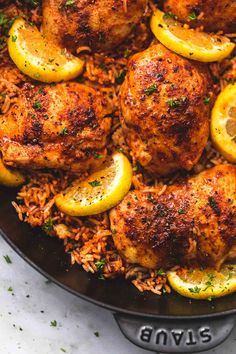 chicken thighs with lemons and rice in a skillet