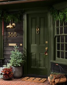 a green front door with two potted plants on the side and a sign that says 360