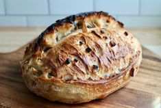 a loaf of bread sitting on top of a wooden cutting board