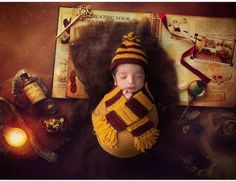 a newborn baby wearing a harry potter hat and scarf is posed in front of hogwarts memorabilia