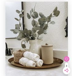 a bathroom sink with towels and flowers in a vase