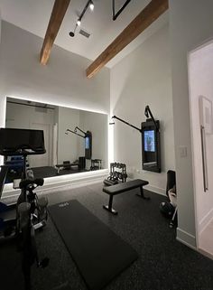 an empty gym with mirrors and equipment on the wall, while lights shine brightly in the background