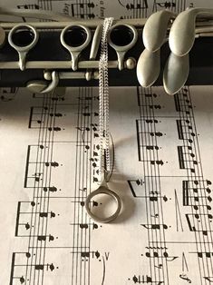 a musical instrument is on top of sheet music with scissors hanging from it's end