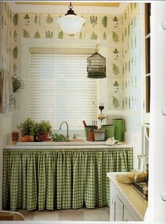 a kitchen with green and white wallpaper, sink and countertop covered in plants