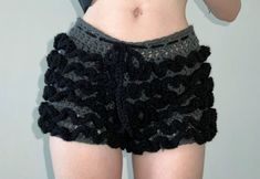 a woman with her cell phone up to her ear and wearing crocheted shorts