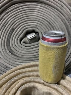 there is a can on the ground next to a hose that has been wrapped around it