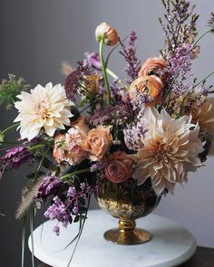 a vase filled with lots of flowers on top of a table