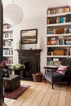 a living room filled with lots of books and furniture