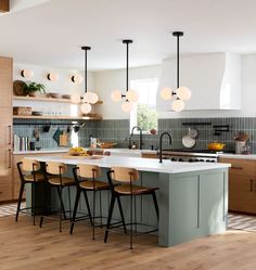 a kitchen with an island and several chairs next to the counter top in front of it