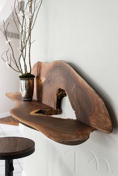 a wooden shelf with vases on top of it next to a wall mounted planter