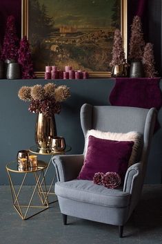 a living room with purple and gold decorations on the wall, two chairs and a side table