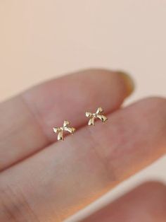 ▪️This Solid Gold Dainty CZ Mini Bow Stud Earring Is made entirely from 10k gold.Very Dainty and Sparkly.Best gift for her. ▪️All Jewelry is made in U.S from our own studio. ▪️All Jewelry is packaged and shipped in a delicate jewelry gift box. ▪️If you are purchasing it as a gift, please feel free to add a personal note. ABOUT THE ITEM ▫️Made to Order.  ▫️10k Solid Gold ▫️Custom Color: Gold ▫️Size:3.5*4.3mm ▫️Necklace Chain and  Bracelet chain stamped with 14k(AU585) hallmark. ▫️Ready to Ship in Aesthetic Stud Earrings, Bow Stud Earrings, Cute Jewelry Gold, Now Earrings, Gold Bow Earrings, Cute Dainty Jewelry, Cute Simple Earrings, Cute Gold Earrings, Gold Earrings Aesthetic