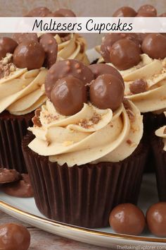 chocolate cupcakes with white frosting and brown candies on a platter