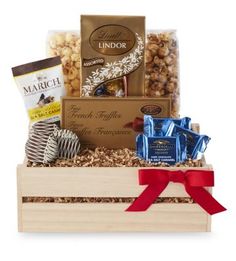 a wooden box filled with chocolates, nuts and other items to make a good gift