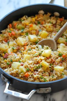 a pot filled with rice and vegetables on top of a table