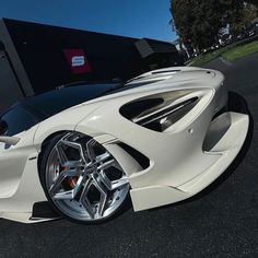 a white sports car parked in front of a building