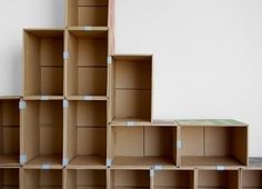 several cardboard boxes stacked on top of each other in front of a white wall and floor