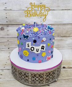 a birthday cake with purple frosting and decorations