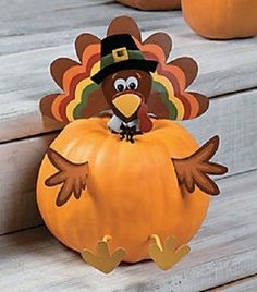 a turkey sitting on top of a pumpkin