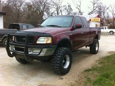 a red pick up truck parked in a driveway