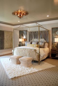 a bedroom with a four poster bed and white rugs