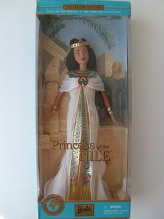 the doll is in its box and has a gold crown on it's head