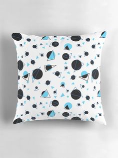 a white pillow with blue and black shapes on it