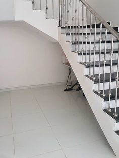 there is a white stair case next to the black and white stairs in this room