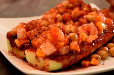 a white plate topped with french toast covered in beans and meat sauce next to a cup of coffee