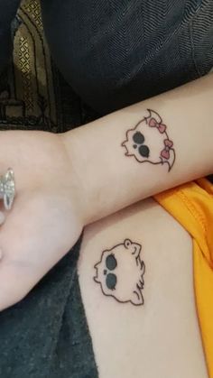 two people with matching tattoos on their arms, one has a cat and the other has a dog