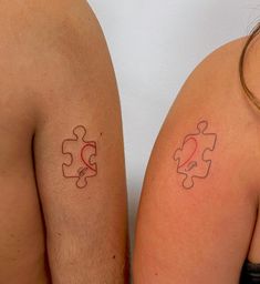 two people with matching tattoos on their arms and shoulder, both have puzzle pieces painted on them