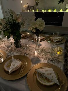 the table is set with white and gold plates