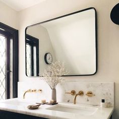 a bathroom with two sinks and a large mirror over the sink in front of it