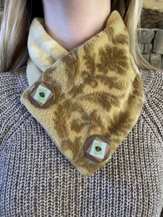 a close up of a woman wearing a scarf with buttons on the neck and an animal print design