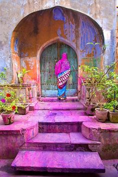 a woman walking down some steps with potted plants