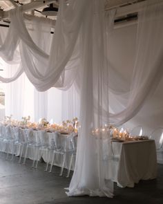 a room filled with lots of tables covered in white drapes