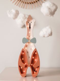 a wooden toy with lights on it sitting on a table next to a sun and clouds