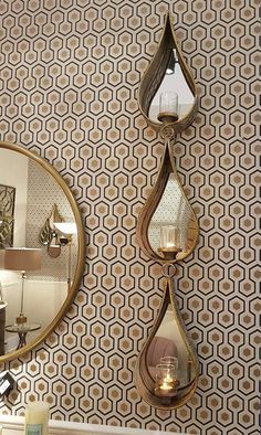 a bathroom with a mirror and wallpaper on the wall next to a candle holder