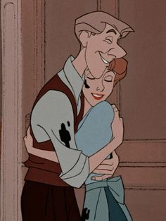 the prince and princess hugging each other in front of an open door with their arms around one another