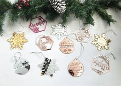 christmas ornaments and pine cones on a white surface with snowflakes, fir tree branches and other holiday decorations