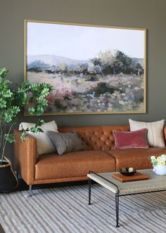 a living room filled with furniture and a painting on the wall