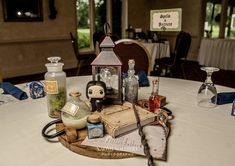 there are many bottles on the table with books and other items around it, including an old book