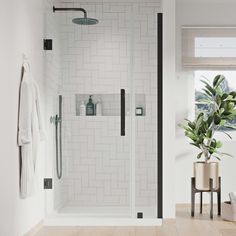 a white tiled bathroom with a glass shower door