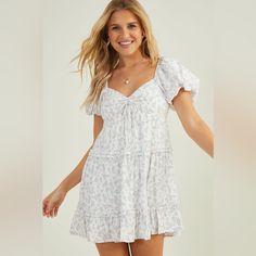 Embrace Timeless Elegance In This Floral Cinched Mini Dress, Boasting Delightful Puff Sleeves And Ruffle Trim. Designed To Accentuate Your Silhouette With A Cinched Top, This Dress Effortlessly Captures Attention With Its Details. Fit: Fit & Flare Closure: Slip On Materials: 55% Rayon, 45% Polyester, Lining; 100% Polyester Lined Short Sleeve White Mini Dress With Gathered Neckline, White Ruched Tiered Dress, Feminine White Puff Sleeve Dress With Gathered Neckline, White Dress With Gathered Neckline For Spring, White Puff Sleeve Mini Dress With Smocked Back, Feminine White Puff Sleeve Dress With Ruffle Hem, White Tiered Dress With Gathered Sleeves, Casual White Dress With Gathered Neckline, White Ruched Mini Dress For Daywear