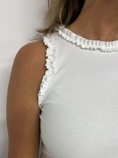 Your go to white top is here!  White ribbed knit fabric that is super stretchy shapes this classic tank style top with ruffle detailing at the shoulder and neckline. This top is fitted making it the great option for tucking into skirts, shorts or pants, it is the perfect base for layering... we can't wait to see how yo Trendy White Ruffled Tank Top, Cotton Stretch Ruffle Tank Top, White Stretch Tank Top With Ruffles, Cotton Stretch Tank Top With Ruffles, Stretch Cotton Tank Top With Ruffles, White Fitted Top With Ruffles, Stretch Top With Ruffled Straps And Details, White Fitted Ruffled Tank Top, White Fitted Ruffle Tank Top