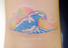 a small tattoo on the ankle of a woman's leg with an ocean wave painted on it