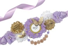 a purple and gold flower bracelet with nameplates on the front, along with two ribbons