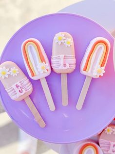 four ice cream pops are on a purple plate