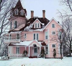 a large pink house with snow on the ground